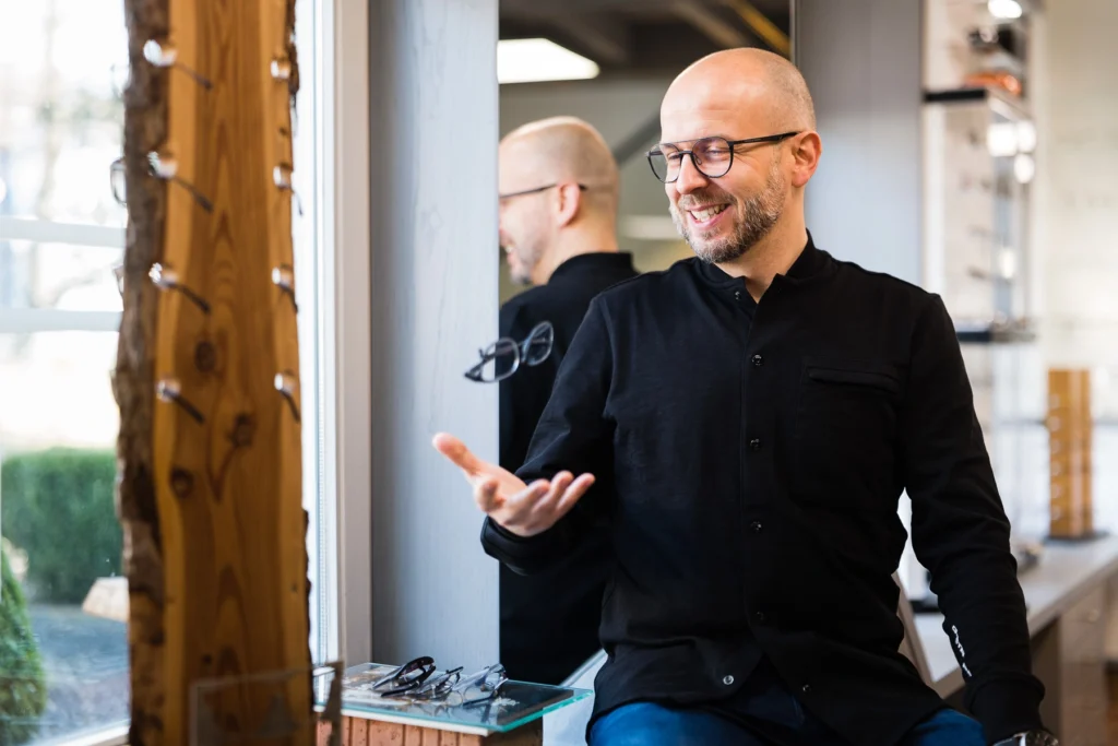 optik am Haarenufer, Inhaber Niko Bolle wirft eine Brille in die Luft.